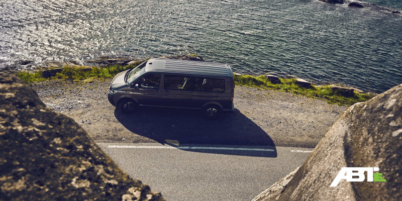 Un utilitaire Volkswagen Caravelle arrêté sur le bord d’une route, surmontant une falaise.