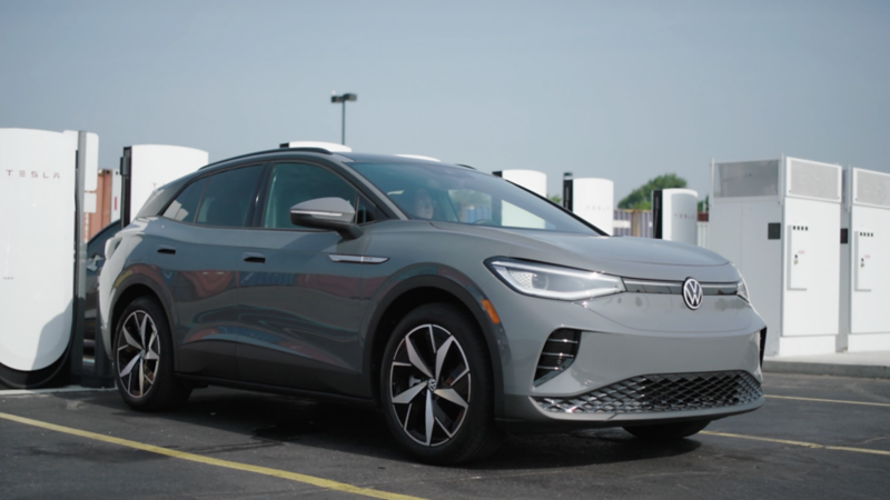 Volkswagen ID.4 parked at a Tesla® Supercharger station with NACS DC fast-charging adapter.