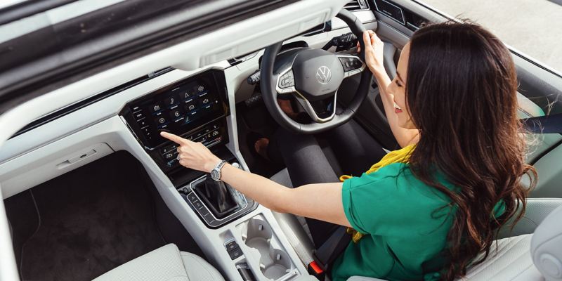 Woman using infotainment system in Volkswagen Passat wagon