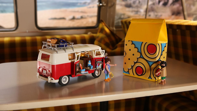 Miniatura del Bulli Volkswagen, realizzata da Playmobil, appoggiata su un tavolino.