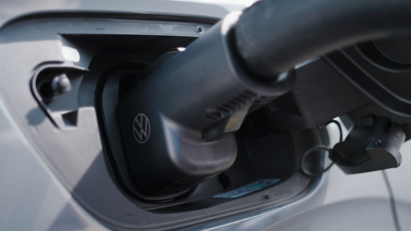 Volkswagen ID.4 charging with NACS DC fast-charging adapter at a Tesla® Supercharger station.
