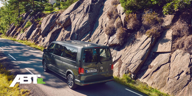 Une Volkswagen Caravelle roule sur une route de montagne.