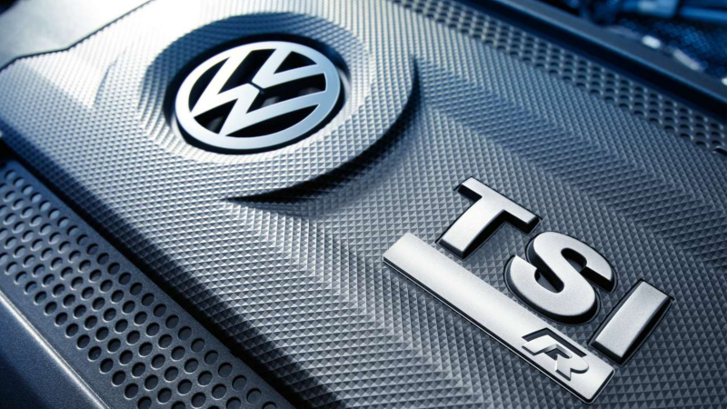 Gros plan sur le capot moteur texturé d'une Volkswagen, affichant le logo VW et les inscriptions chromées "TSI" et "R", indiquant un moteur turbo essence et la version sportive.