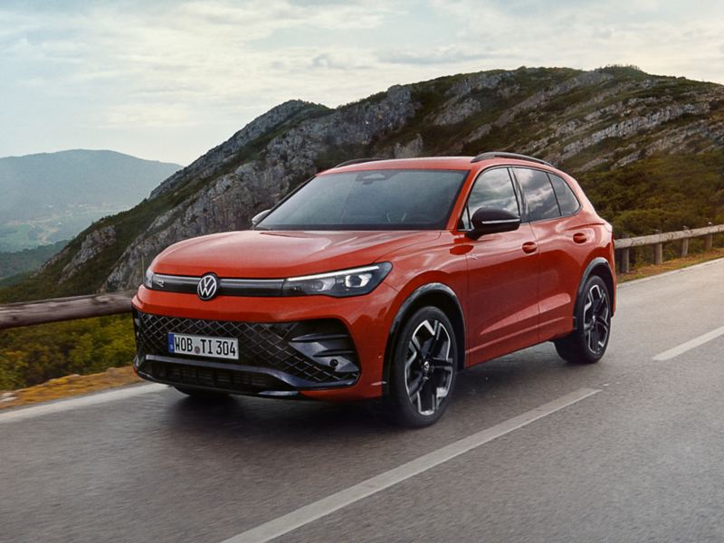 A red Tiguan being driven on a road