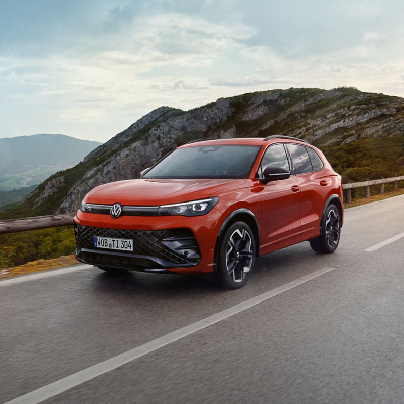 A red Tiguan being driven on a road