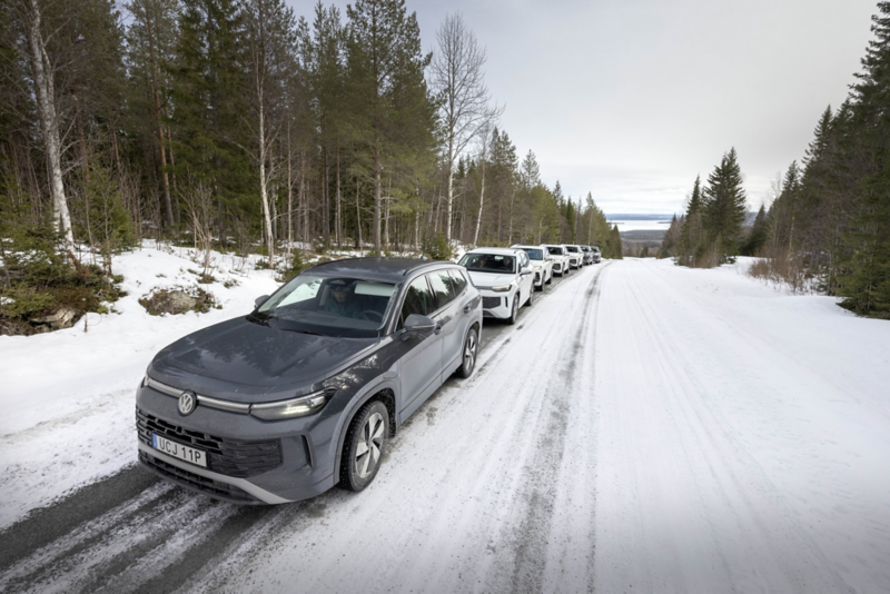 Flera Tayron parkerade på rad längs en väg. Vinterlandskap