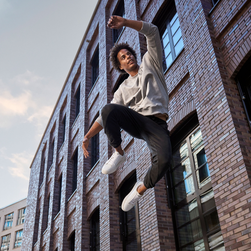 Man in VW lifestyle clothing jumps into the air