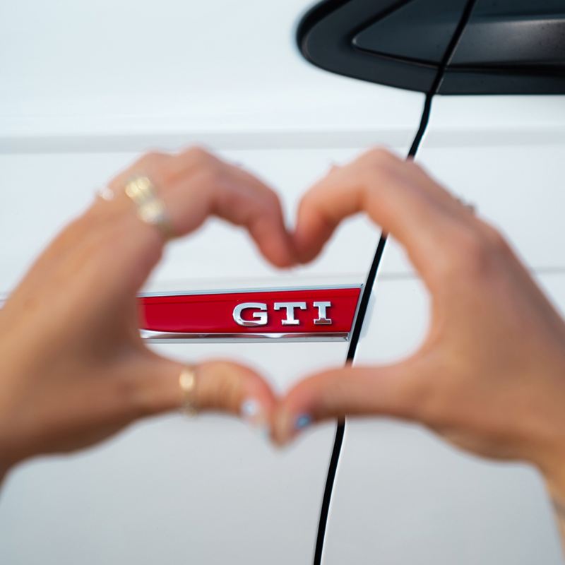 Zwei Hände formen ein Herz um ein „GTI“-Logo
