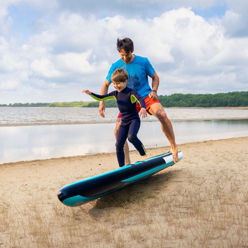 Vater und Sohn üben das Stehen auf einem Stand-Up-Paddle Board