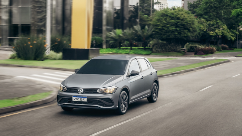 Volkswagen Polo Track gris circulando por una avenida urbana.