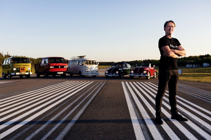 Per-Inge står framför sina Volkswagen bilar på en asfalterad väg