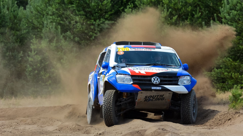 Sportowy Volkswagen na piaszczystej drodze.
