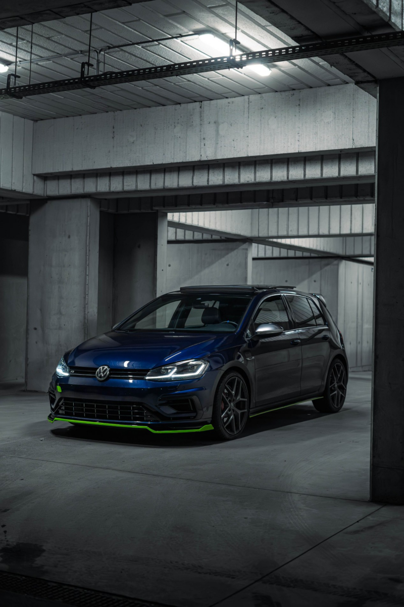 Granatowy Volkswagen w parkingu podziemnym. 