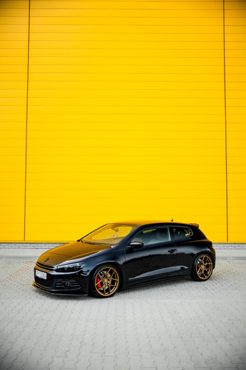 Czarny Volkswagen na żółtym tle.