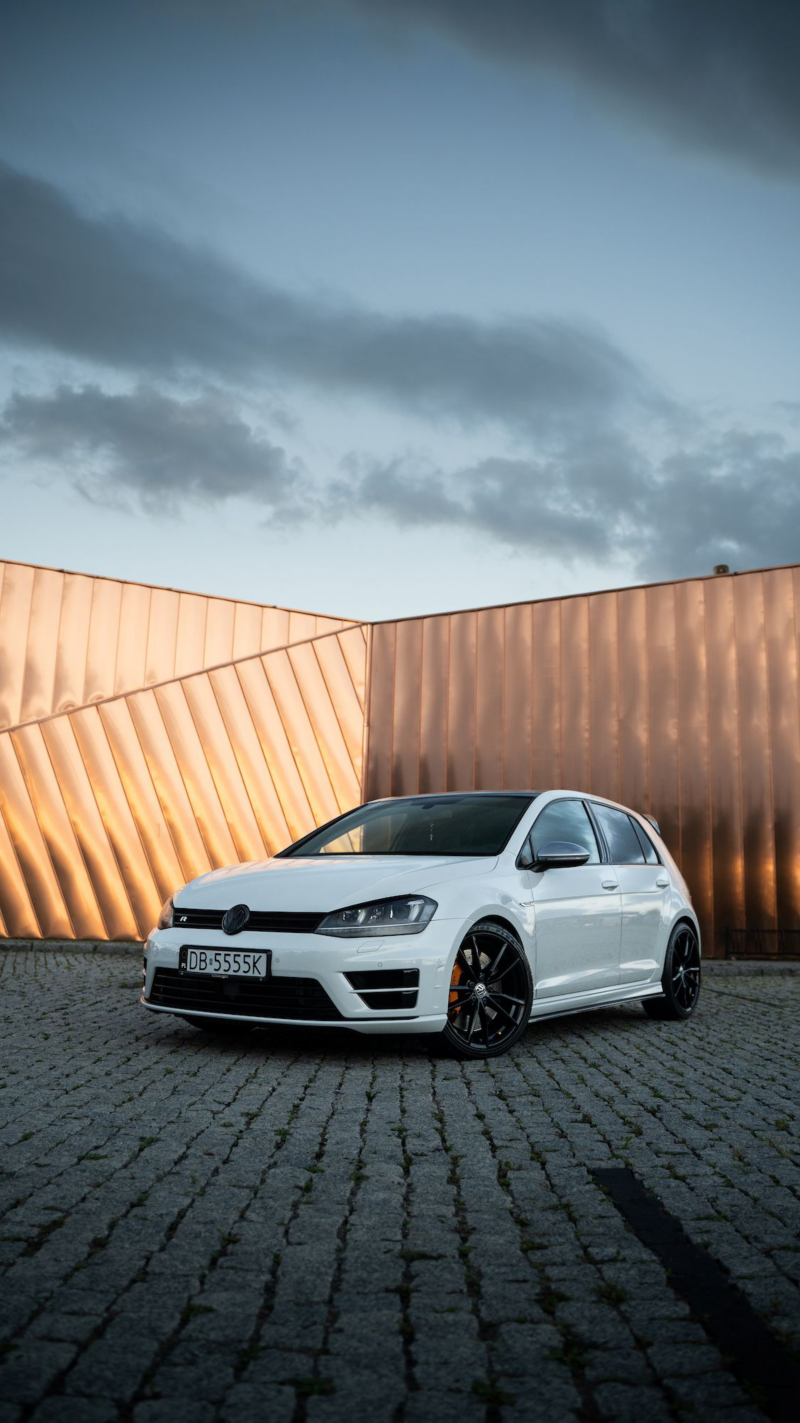 Biały Volkswagen na złotym tle.