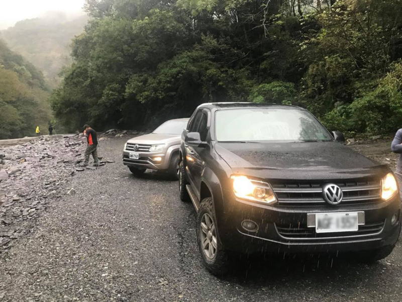 2台Amarok在溪邊石礫地合照，前方是珍珠黑的Amarok、後方是璀璨銀
