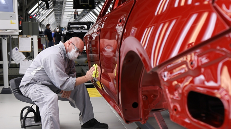 Chattanooga employee working on exterior of red Volkswagen.