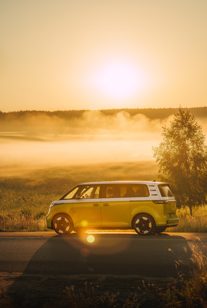 Volkswagen ID.Buzz stoi zaparkowany przy łące podczas wschodu słońca
