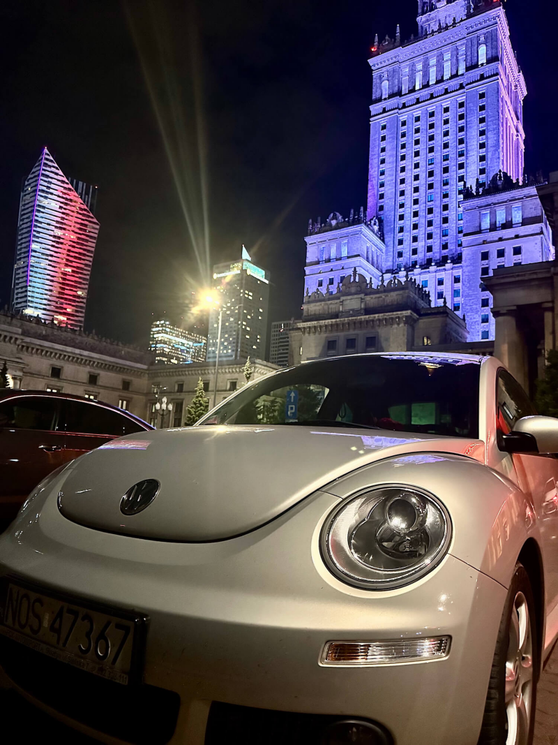 Szary samochód volkswagen na tle Pałacu Kultury i Nauki w Warszawie