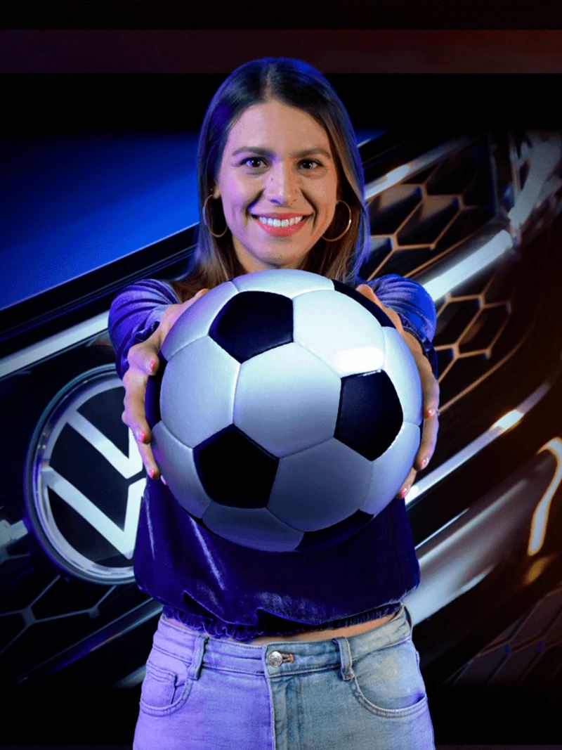 Presentadora de Noticias Volkswagen sosteniendo un balón de fútbol.