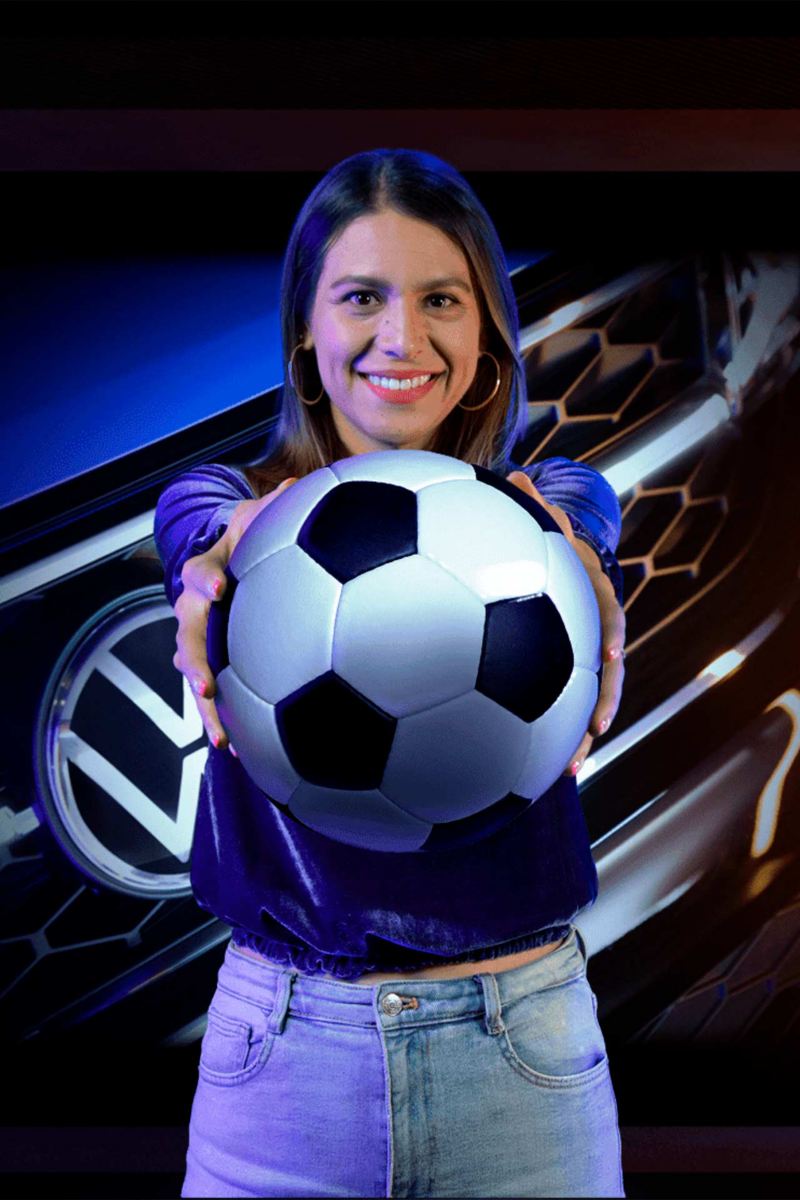 Presentadora de Noticias Volkswagen sosteniendo un balón de fútbol.