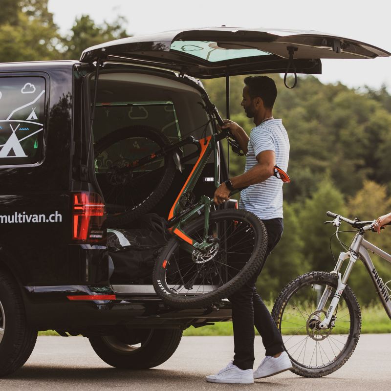 Un homme et une femme s'occupent de deux vélos dans le multivan.