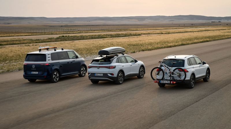 VW ID. Buzz, VW ID.4 et VW Tiguan garés les uns à côté des autres sur une large route