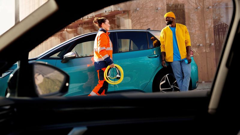 Een servicemedewerker van de Pechbijstand van VW voor auto-ongevallen of autopech helpt een man met zijn Volkswagen