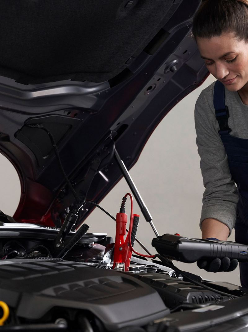A service employee checks the VW battery – Volkswagen car batteries