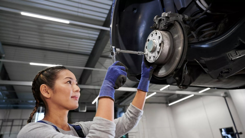 Volkswagen monteur vervangt de remblokken in de werkplaats