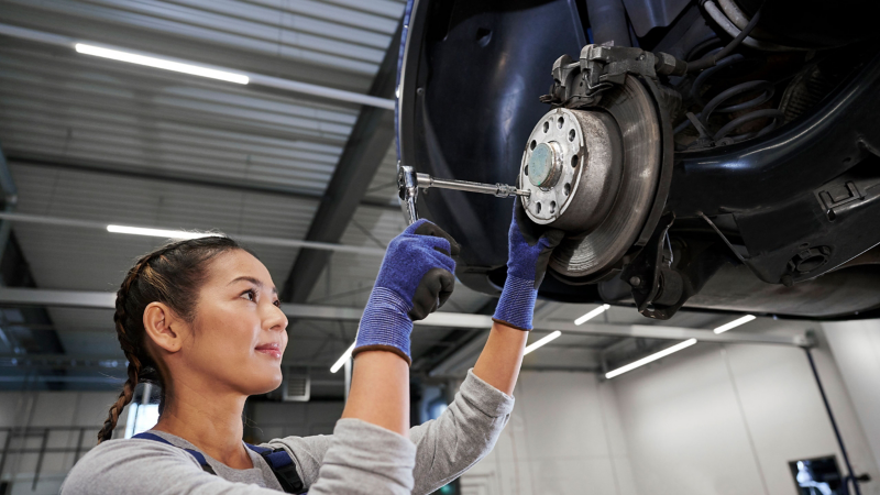VW service employee inspects brake disc on a VW car