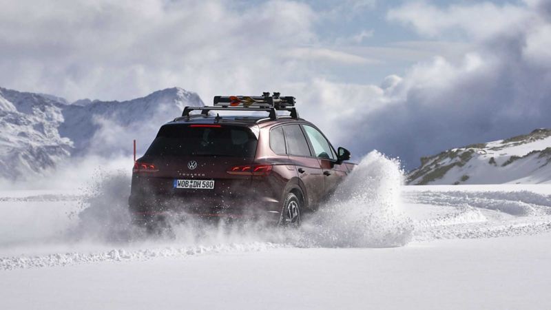 Ripresa di un'auto Volkswagen nel momento della frenata su un suolo ricoperto di neve.