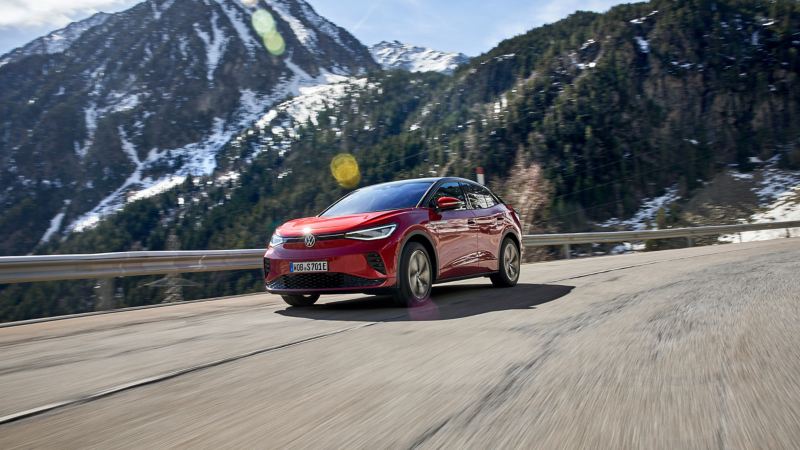 VW ID.5 GTX auf einer Strasse, schneebedeckte Berge im Hintergrund