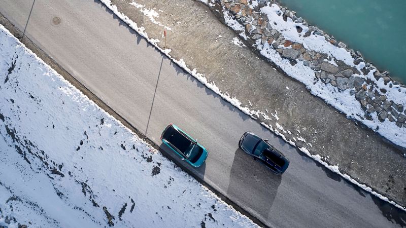 Deux Volkswagen sur la route dans un paysage enneigé