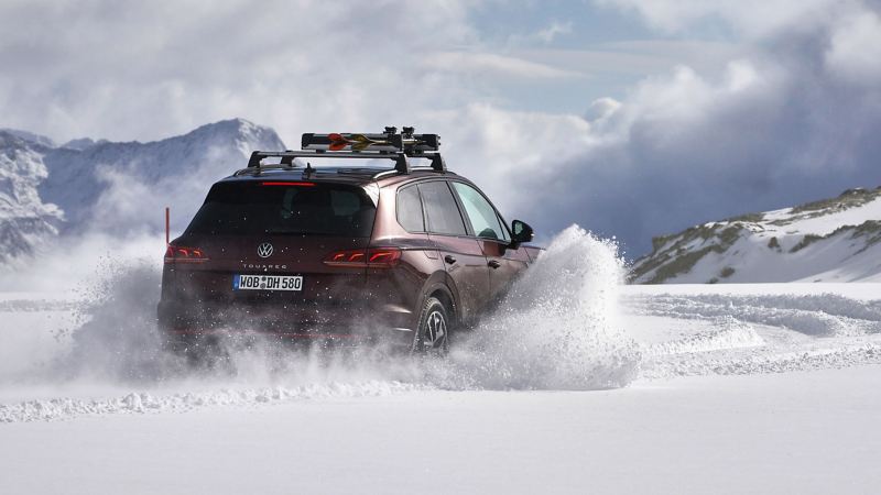 Un Volkswagen circula por una carretera invernal y remolina nieve