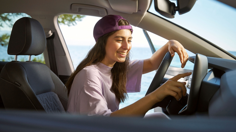 Mujer utilizando el sistema de infoentretenimiento en su Volkswagen