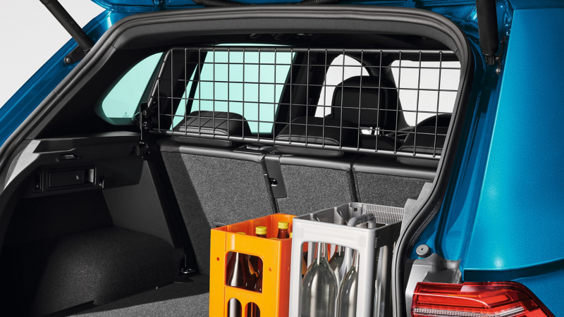 Zwei Getränkekisten im Kofferraum eines VW Autos, dahinter Gepäcktrenngitter von VW Zubehör