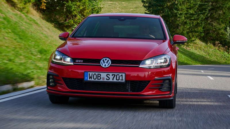 Czerwony VW Golf 7 jadący wiejską drogą