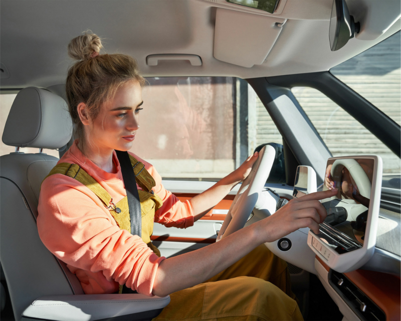 Mujer que usa la última versión de software en un vehículo eléctrico.