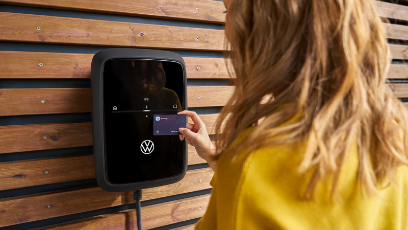 Frau aktiviert ID. Charger Wallbox mit Ladekarte