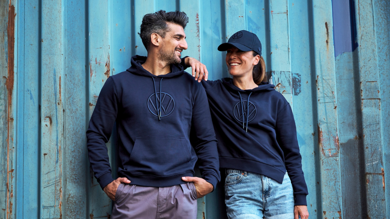 Mann und Frau mit Kleidung aus der VW Kollektion – VW Fanartikel