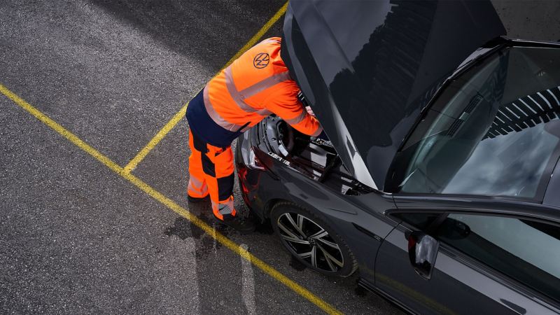 A VW service employee checks a VW car 