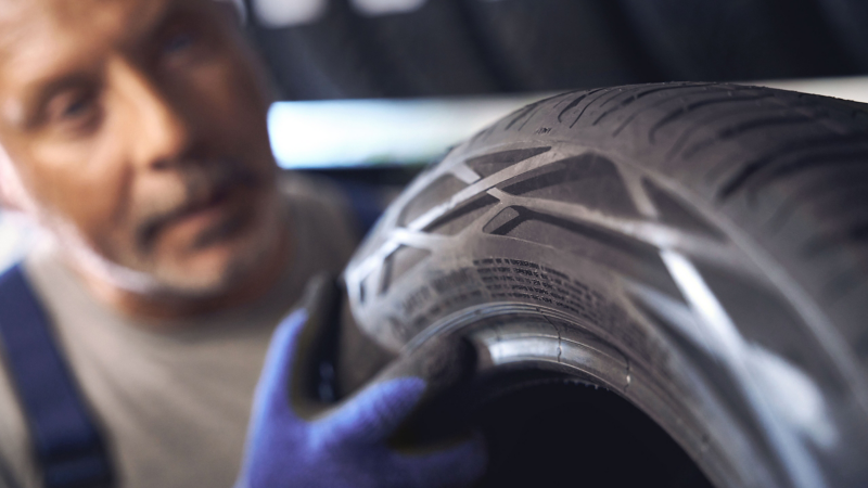 VW Servicemitarbeiter prüft VW Reifen