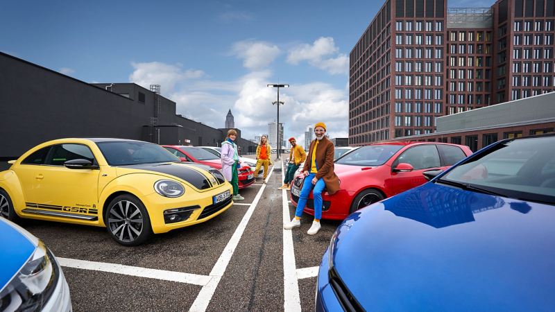Happy drivers next to their older Volkswagen models