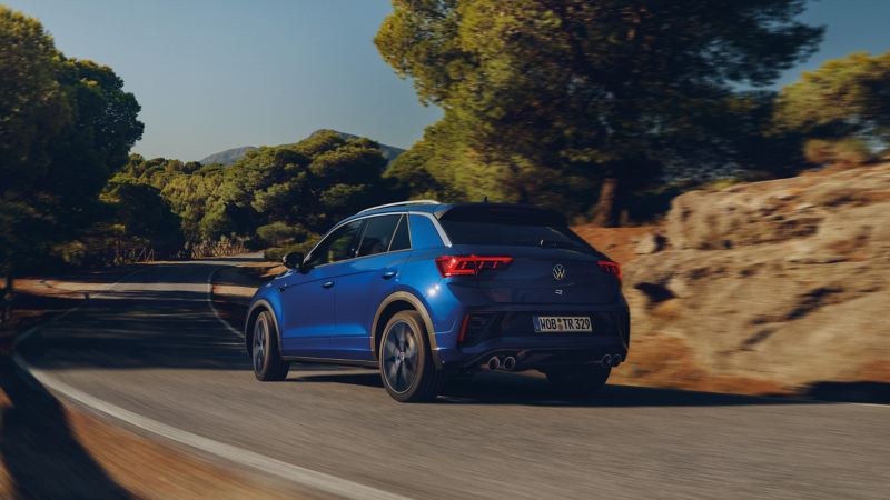 Achteraanzicht van de VW T-Roc R, die een straat voorbijrijdt