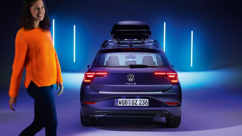 Vrouw voor een VW Polo met dakkoffer van VW-accessoires