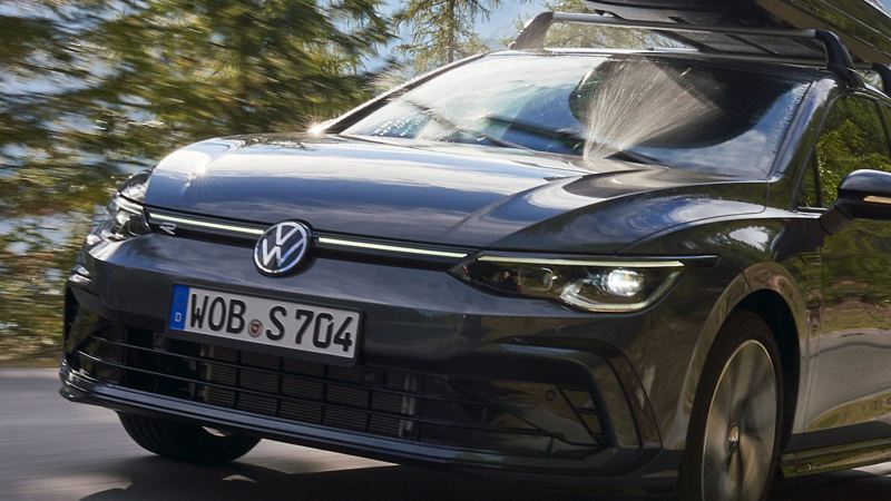 Samochód marki VW z boksem dachowym jadący malowniczą drogą – w tle górski plener
