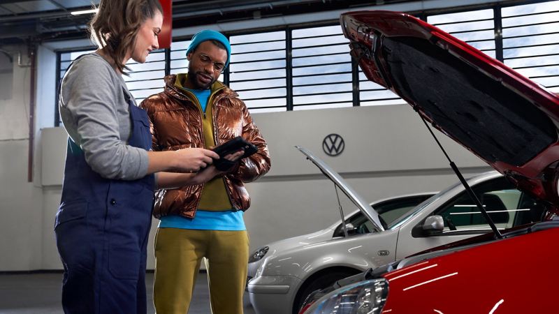 Pracownik serwisu VW i klient podczas przeglądu samochodu – Serwis Volkswagen