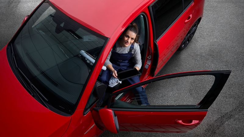 Eine VW Servicemitarbeiterin überprüft den Innenraum eines Golf 7
