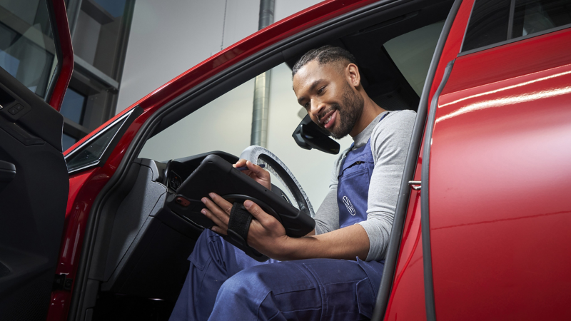 VW Servicemitarbeiter checkt Innenraum eines VW Autos